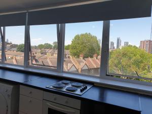 a kitchen with a view of the city from a window at Private ROOMS ONLY with SHARED bathroom near Elephant & Castle (zone 2) in London