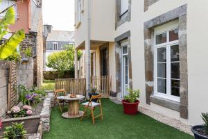 a small garden with a table and chairs on a patio at Ti Massa - Petit cocon avec jardin à St Servan in Saint Malo