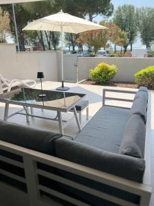 Vista mare Grado في غرادو: أريكة وطاولة ومظلة على الفناء