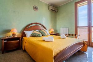 una camera da letto con un letto e due asciugamani di Casa Vacanza Germano - Vivi un soggiorno da sogno - 160m2 di comfort e vista mare in Sicilia! a Pachino