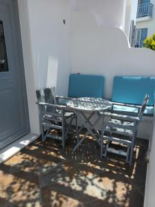 a patio table and chairs on a balcony at Theofanis Studios in Agia Anna Naxos