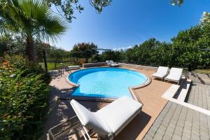 einen Pool mit weißen Stühlen und einem Pool in der Unterkunft Apartments Vallis Rabiosa in Zadar