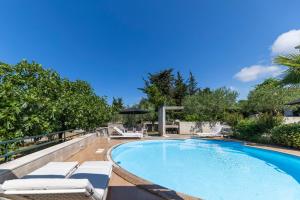 einen Pool mit Chaiselongues neben einem Pool in der Unterkunft Apartments Vallis Rabiosa in Zadar