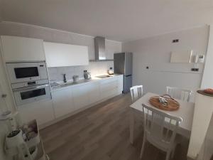 a kitchen with white cabinets and a table with chairs at Apartamento en Águilas con amplia terraza y piscina in Águilas
