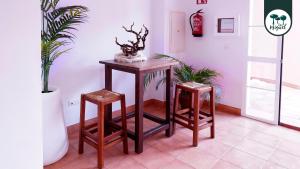 una mesa y dos taburetes en una habitación en Hostal Rte. Casa Miguel en Matalascañas