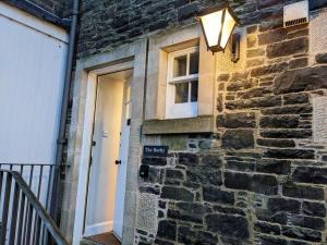 a door to a brick building with a light on it at The Bothy at Bowhill in Selkirk