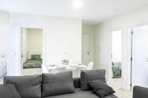a white living room with a couch and a table at Apartamento Roncudo 4º planta in A Coruña