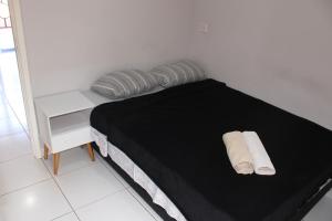 a bedroom with a bed with two towels on it at Casa Ourinhos Pet Friendly in Ourinhos