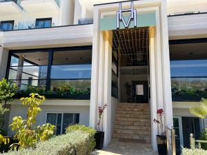 una puerta delantera de un edificio con escaleras y plantas en Hotel Mare en Ksamil