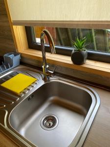a kitchen sink with a faucet and a window at wood house in Mestia