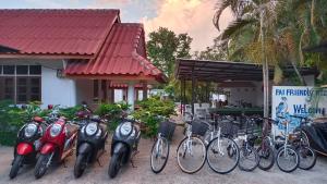 Pai Family Resort في باي: مجموعة من الدراجات متوقفة أمام المبنى