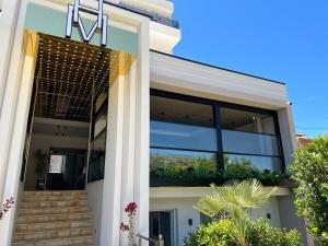 una casa con un balcón con plantas. en Hotel Mare en Ksamil