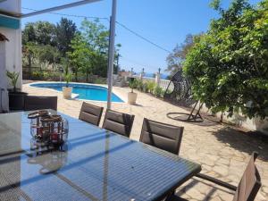 a glass table with chairs and a swimming pool at Casa Felic 12 personen, familiehuis met hottub in Lloret de Mar