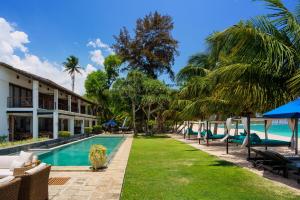 a resort with a swimming pool and palm trees at Lantern Boutique Hotel by Reveal in Mirissa