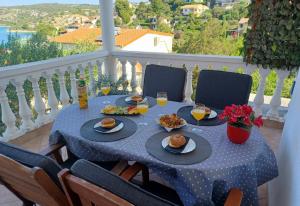 a table with food and drinks on a balcony at Apartments Sonja Sevid in Sevid