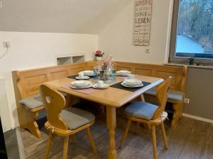 een eettafel met stoelen en een houten tafel bij Ferienwohnung mit Ausblick in Mömbris +29 foto's
