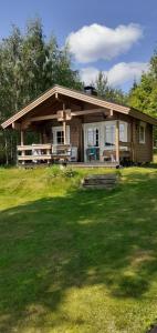 a small house with a porch and a grass field at Villa Niki in Telataipale