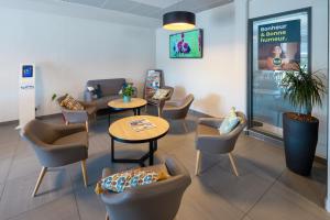 a waiting area with chairs and tables in a waiting room at B&B HOTEL Troyes Magasins d'usine in Troyes