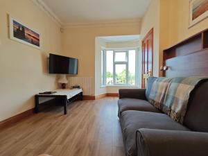 ein Wohnzimmer mit einem Sofa und einem TV in der Unterkunft Mountain View in Donegal