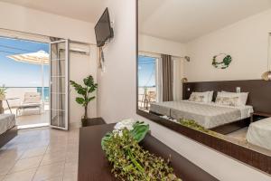 a bedroom with a bed and a view of the ocean at Mouria Studios & Apartments in Laganas