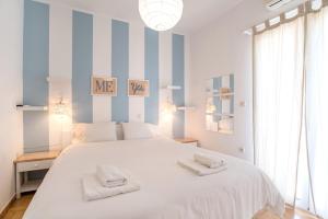 1 dormitorio con 1 cama blanca grande y 2 toallas en Livadia Seaside Studios 14, en Parikia