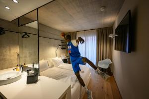 Ein Mann springt mit einem Basketball auf ein Bett in der Unterkunft Hotel Giardino Verdi in Riva del Garda