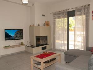 a living room with a couch and a fireplace at Chania Olive Home in Kato Daratso