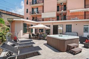 a patio with a hot tub and chairs and a building at Residence Paradiso Bilocale 303 in Moneglia
