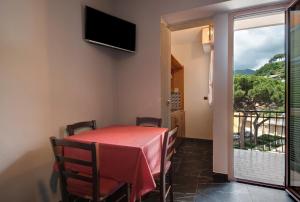 a dining room with a table and a balcony at Residence Paradiso Bilocale 303 in Moneglia
