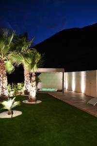 a house with a courtyard with palm trees at night at The Royal Garden by LUCIA DE SU in Santa Cruz de Tenerife