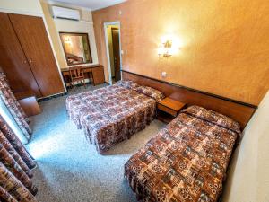 a hotel room with two beds and a table and chairs at HOTEL CONTINENTAL in Calella