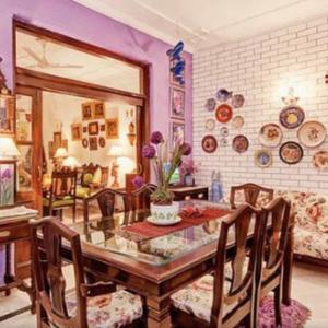 On The House في نيودلهي: غرفة طعام مع طاولة وكراسي ومرآة