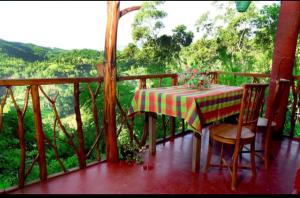 einen Tisch und Stühle auf einem Balkon mit Aussicht in der Unterkunft Rokkyhill in Ella