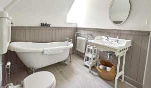 une salle de bain avec une baignoire, un lavabo et des toilettes dans l'établissement Secluded holiday cottage near the Wolds Way, à Wauldby 24 autres photos