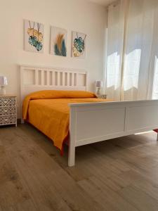 ein Schlafzimmer mit einem Bett mit einer orangefarbenen Decke in der Unterkunft B&B Nonna Maria in Porto Garibaldi