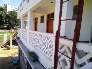 a house with white walls and a balcony at MUNDO GUEST & STUDIO APARTMENTS, MTWAPA,mombasa in Mtwapa