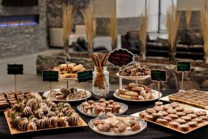 a table filled with different types of pastries and desserts at Days Inn by Wyndham Cranbrook Conference Centre in Cranbrook