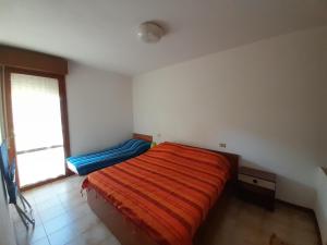 a bedroom with a bed with a red blanket and a window at Le Arselle in Principina a Mare