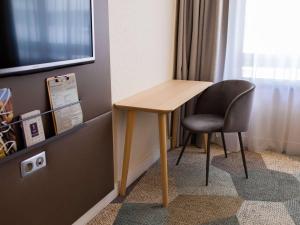 a desk and a chair in a room at Mercure Lorient Centre in Lorient