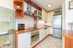 a kitchen with white appliances and wooden cabinets at Apartment Darko in Split +32 photos