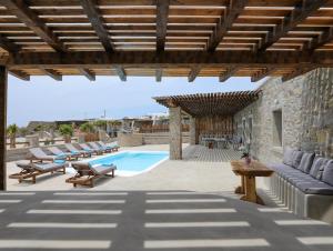 an outdoor patio with a pool and a wooden pergola at The George Villas with Private Pool, & Suite with Jacuzzi, close to Mykonos Town - Chora in Mikonos