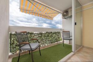2 sillas sentadas en un balcón con vistas en Apartment Darko en Split