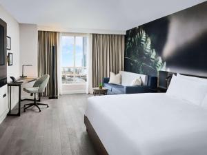una camera d'albergo con un grande letto e una scrivania di The Novotel Toronto Centre a Toronto
