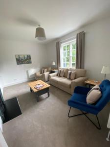 a living room with a couch and a blue chair at Secluded holiday cottage near the Wolds Way 