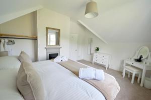 sypialnia z dużym białym łóżkiem z ręcznikami w obiekcie Secluded holiday cottage near the Wolds Way 
