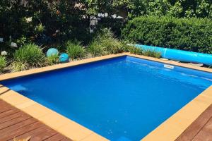 une grande piscine bleue dans une cour dans l'établissement Sojourn on Stewart - Mansfield House with Spa Bath, à Mansfield
