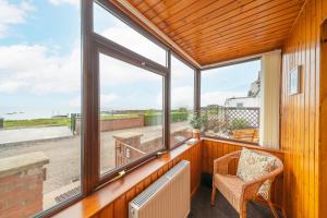a room with windows and a chair and a table at Bellrock View in Panbride