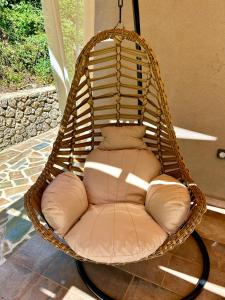 a wicker swing chair sitting on a porch at Anna's cottage house in Perama