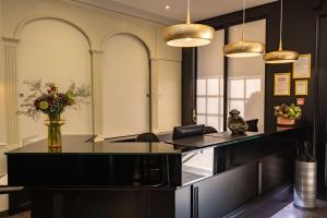 a lobby with a reception desk with a vase of flowers at Best Western Plus Le Moderne in Caen