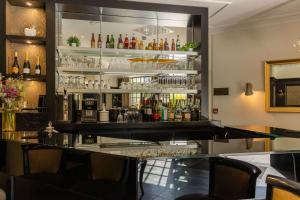 a bar in a restaurant with a glass counter at Best Western Plus Le Moderne in Caen